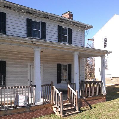 A white house with black shutters and a porch