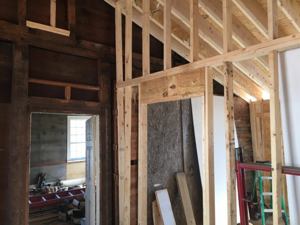 A house is being built with wooden beams and a ladder.
