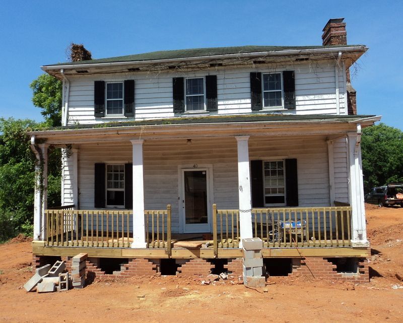 A white house with black shutters and a porch