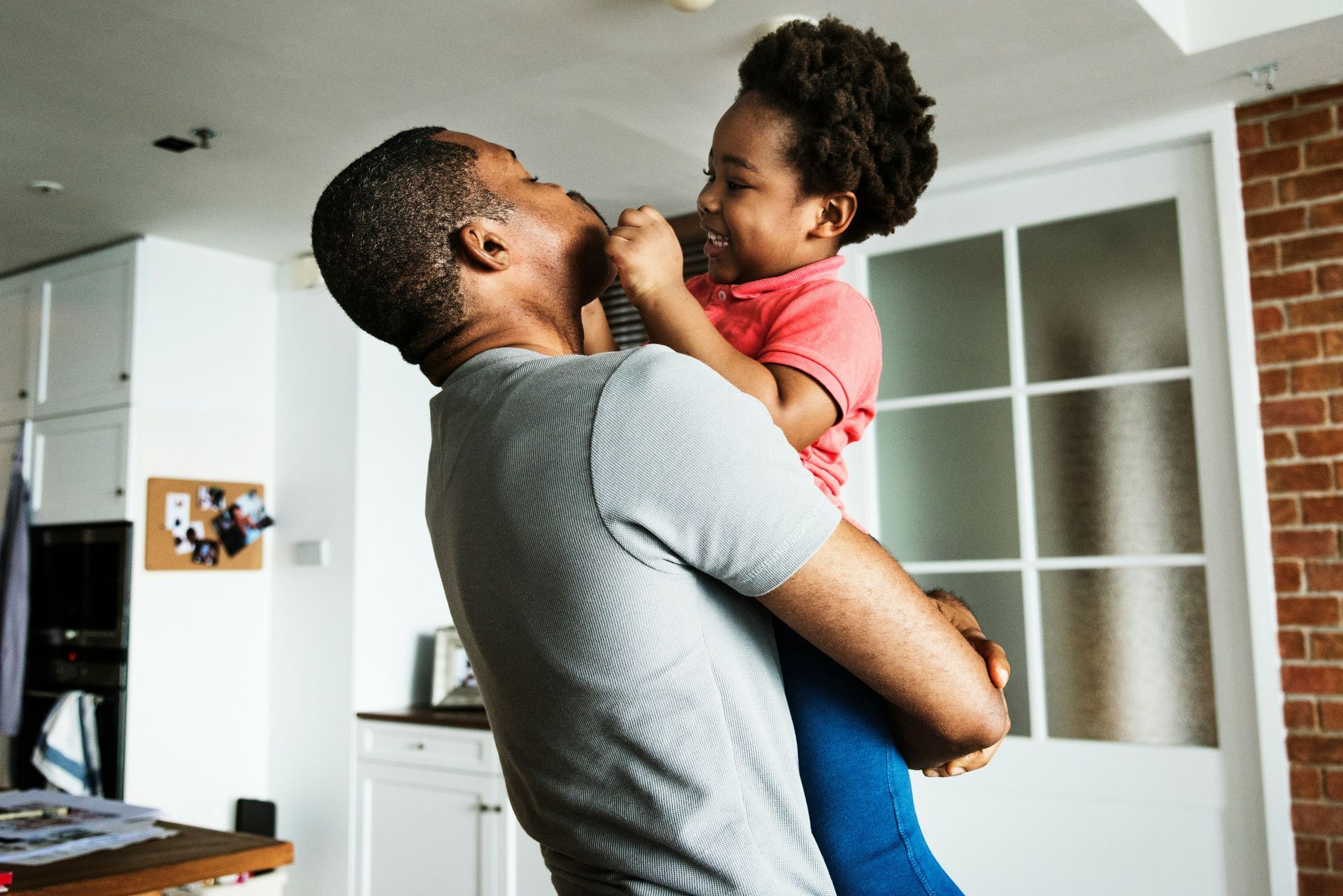 A man and woman are holding a little girl in their arms.