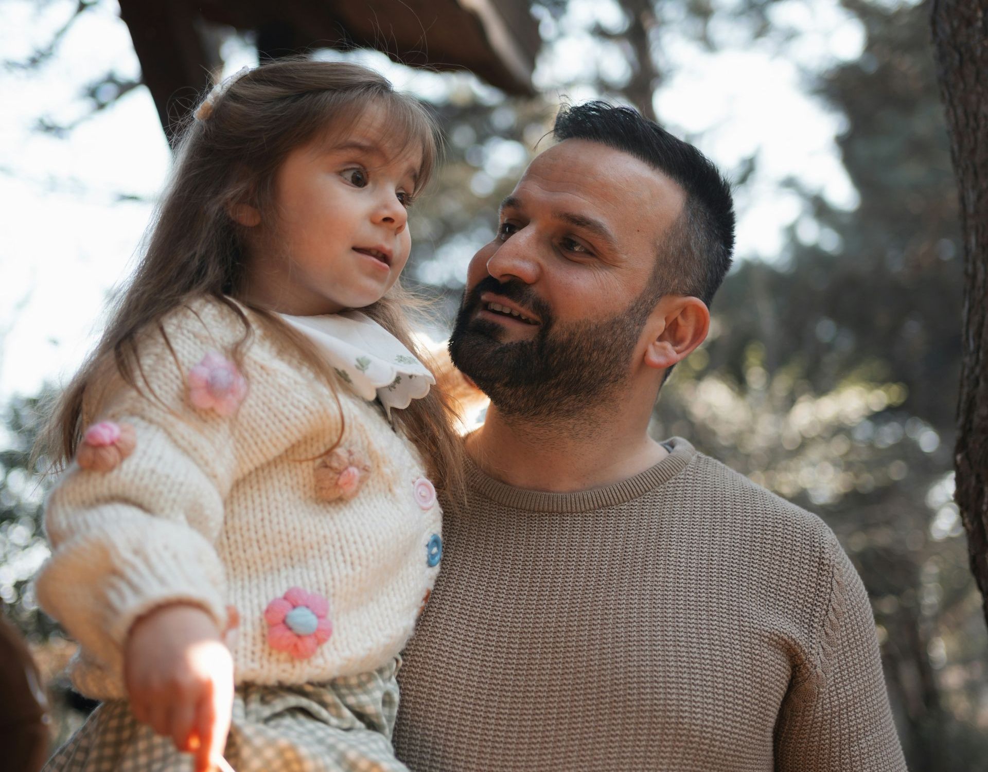 A man and woman are holding a little girl in their arms.