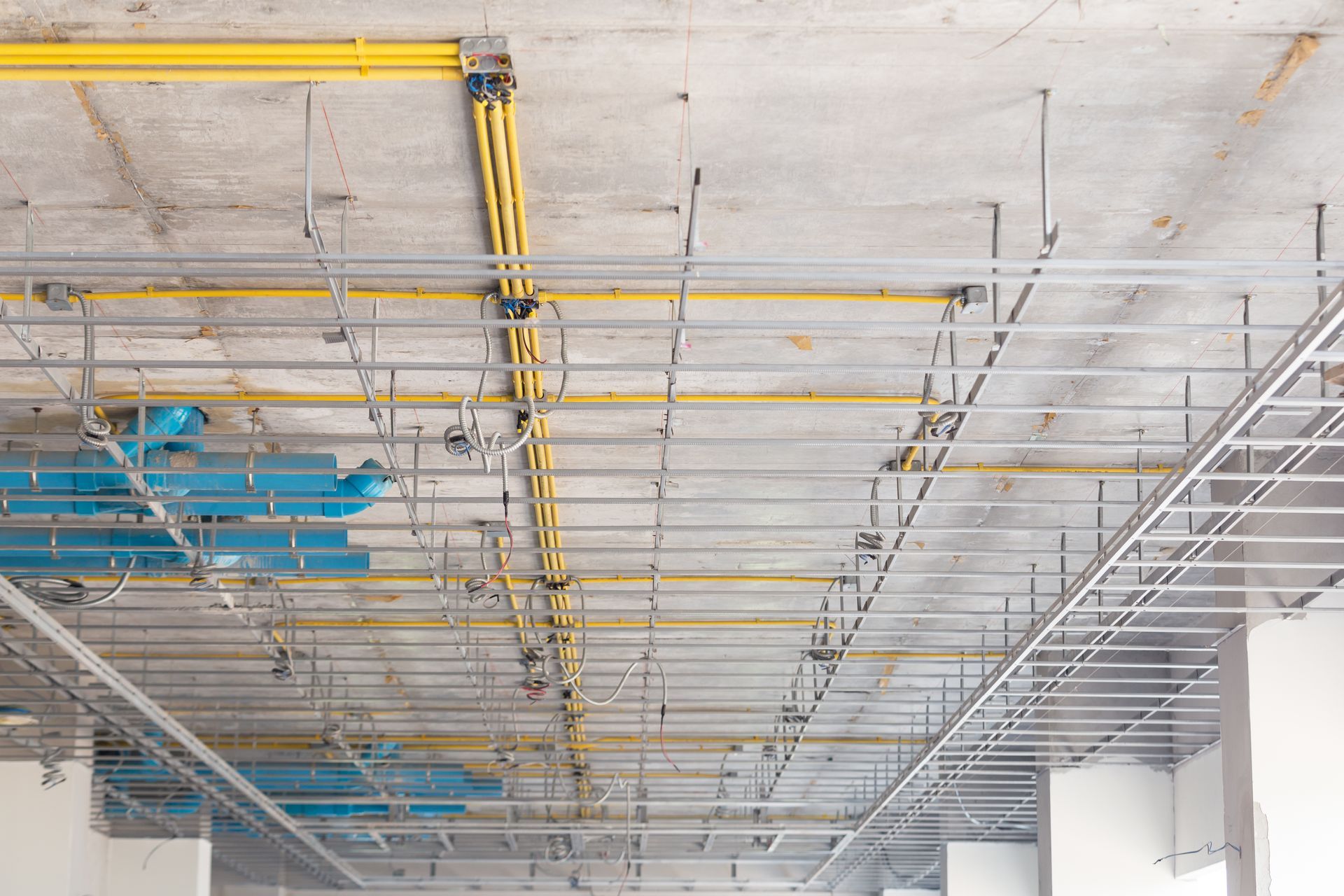 A ceiling with a lot of pipes hanging from it.