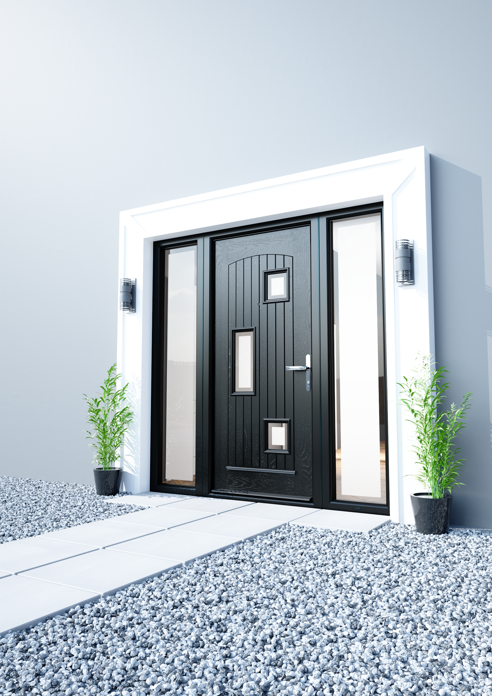 A black door is sitting on top of a gravel driveway next to a white wall.