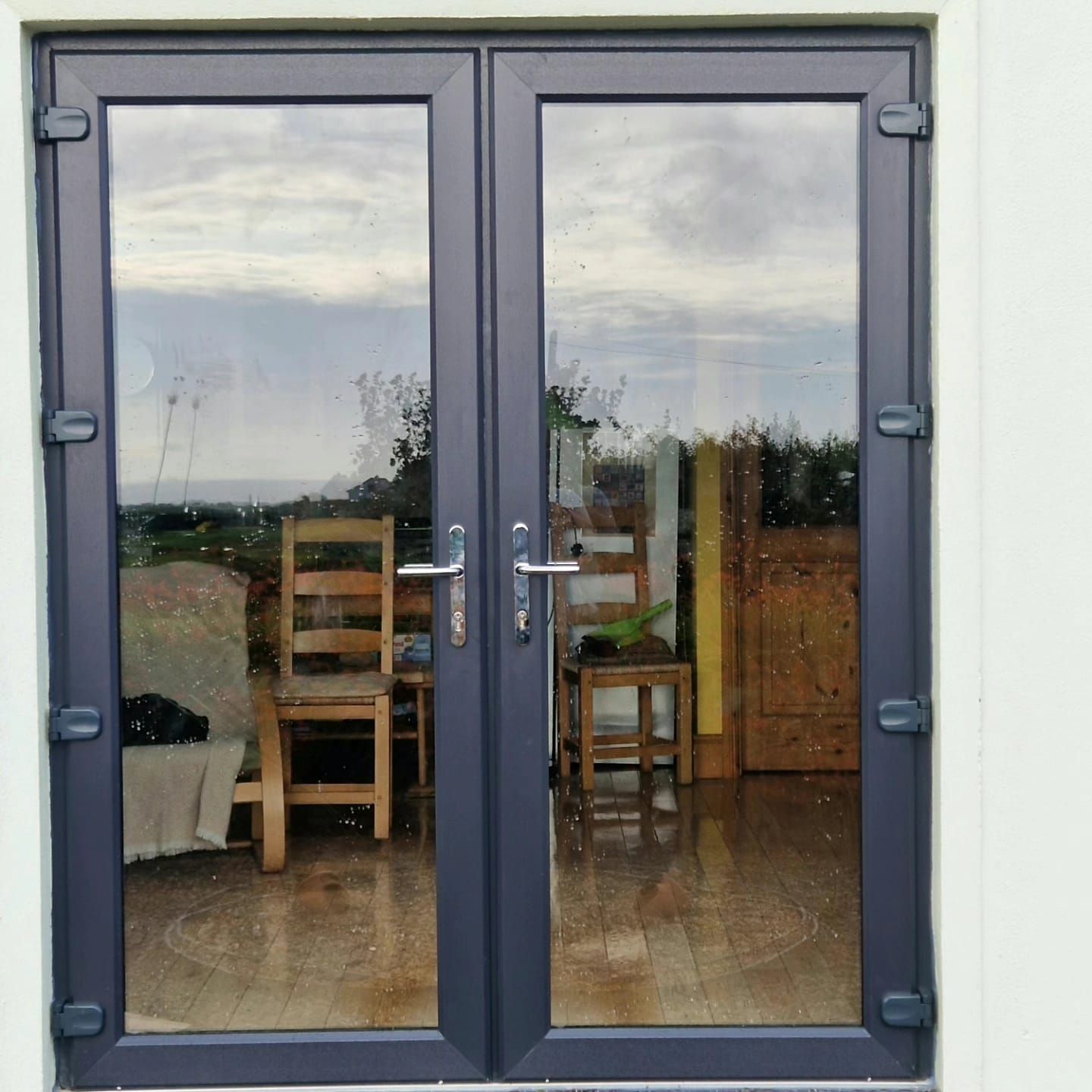A pair of glass doors leading into a room with chairs