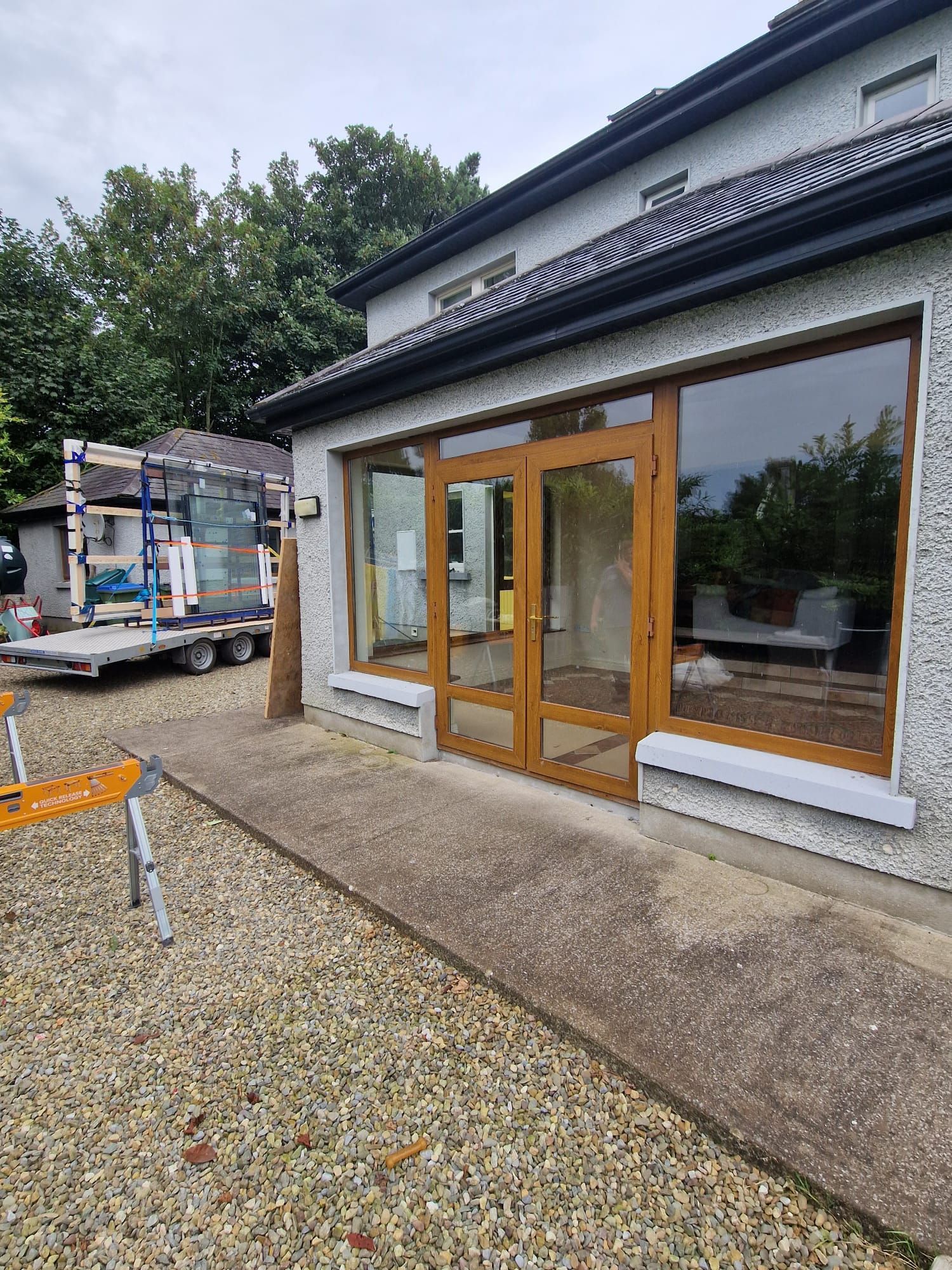 A house with a lot of windows and a truck parked in front of it.