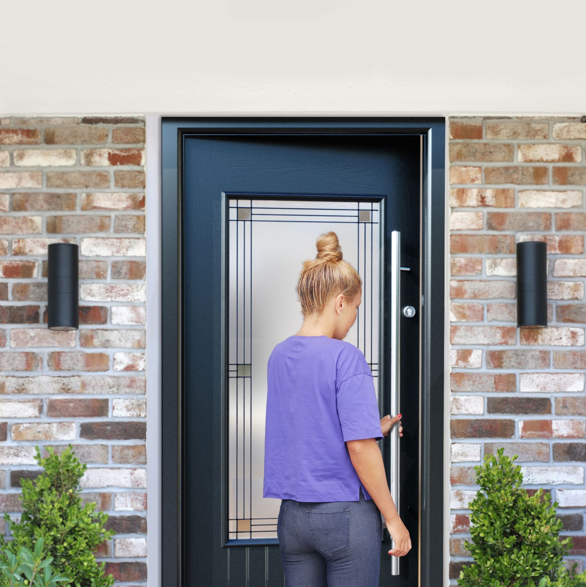 A woman in a purple shirt is standing in front of a black door