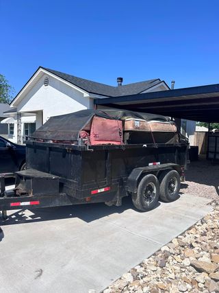 A dumpster trailer is parked in front of a house.