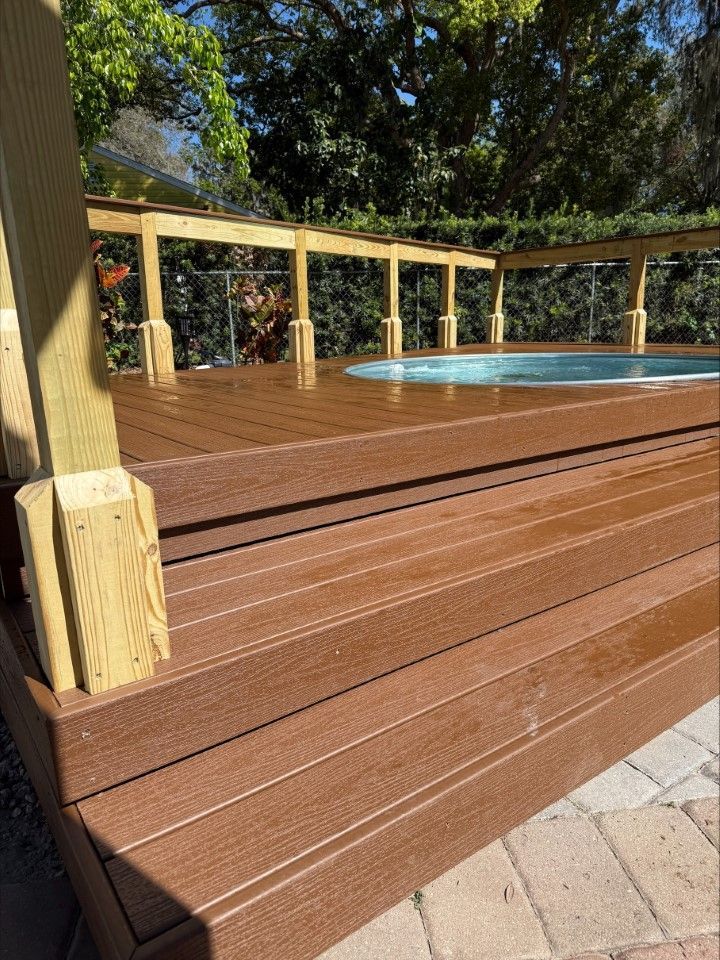 A wooden deck with stairs leading to a swimming pool.