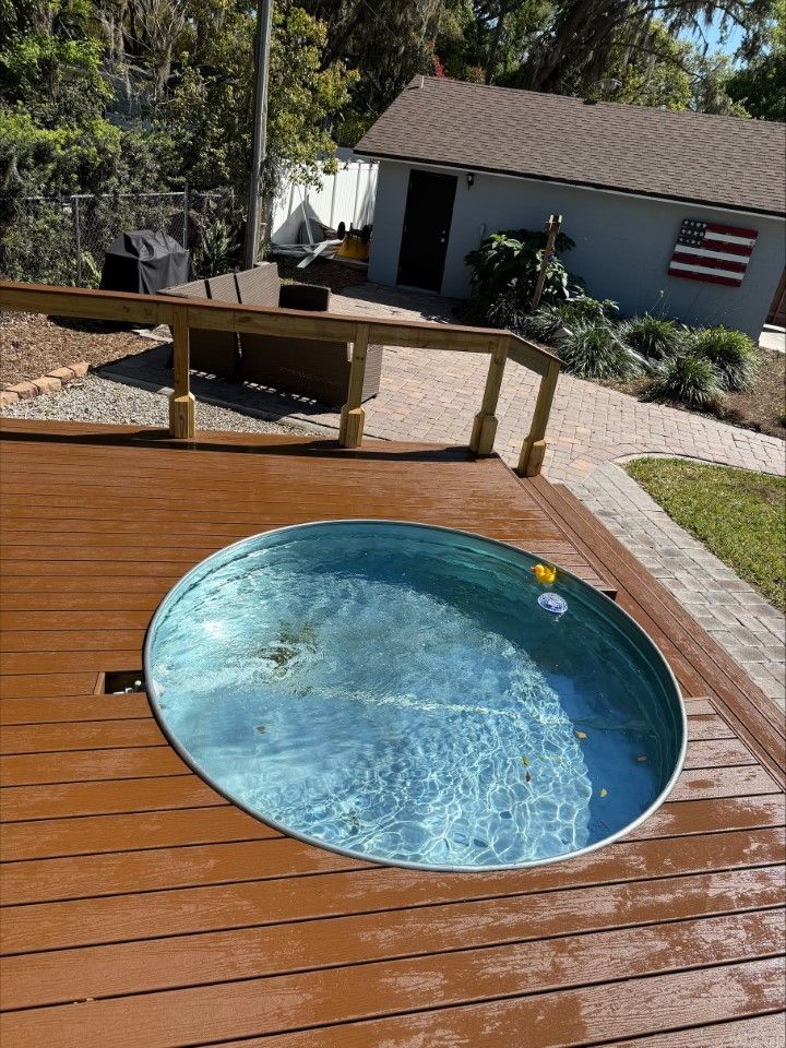 A hot tub is sitting on top of a wooden deck.