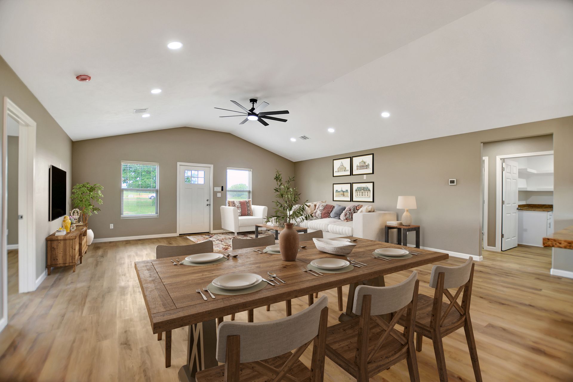 Open-concept living space with dining table, white couch, and neutral walls and flooring.