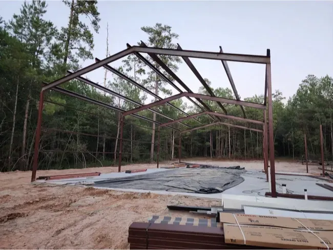 A metal structure is being built in the middle of a forest
