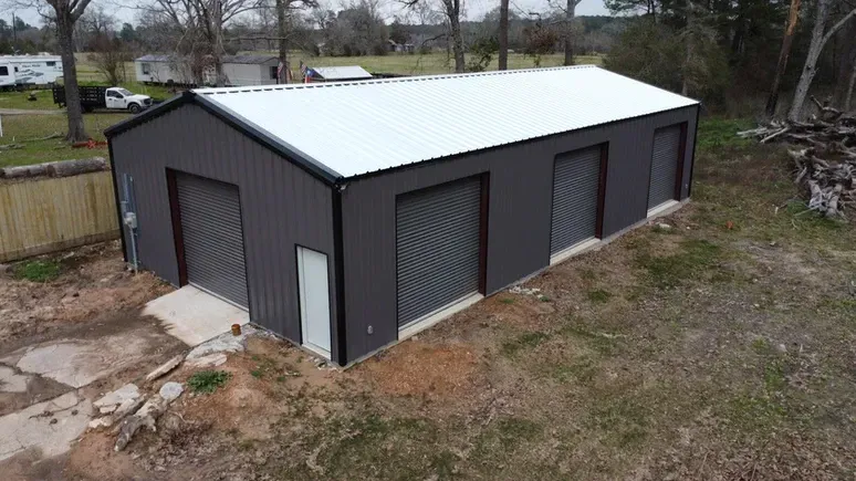 An aerial view of a large metal garage in a field.