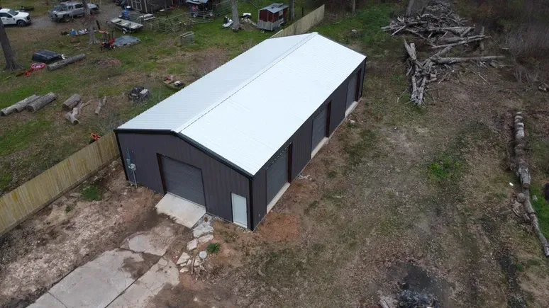 An aerial view of a large metal building in the middle of a field.
