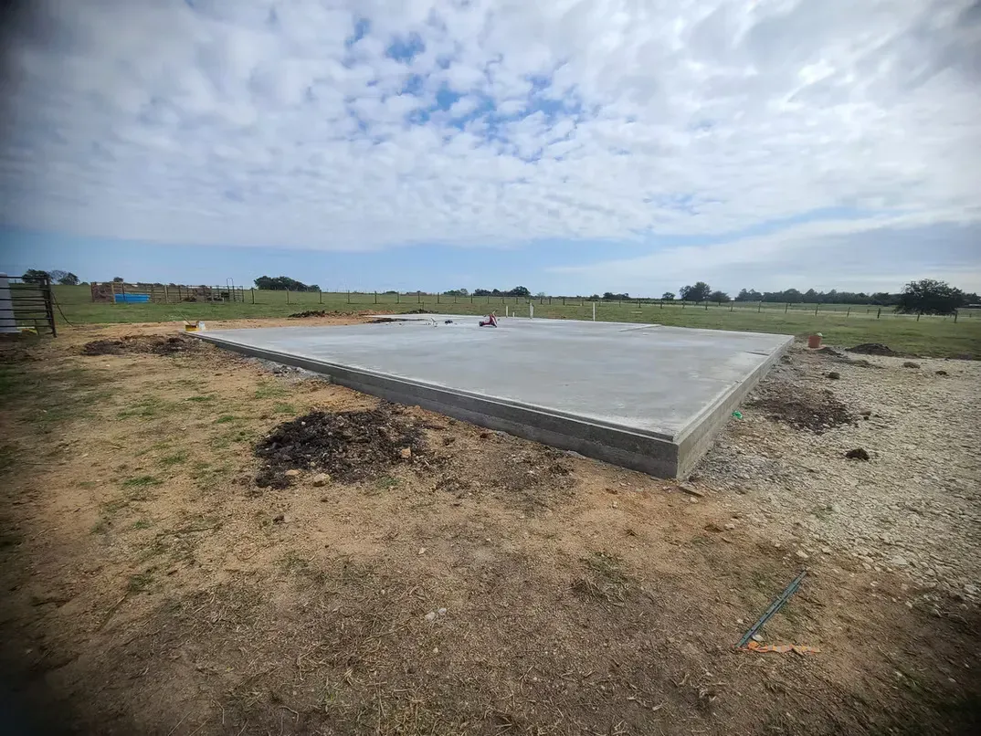A large concrete slab is sitting in the middle of a field.