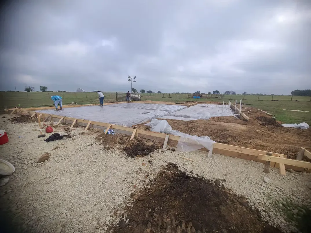 A group of people are working on a construction site in a field.