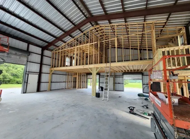 A large building under construction with a ladder and a lift.