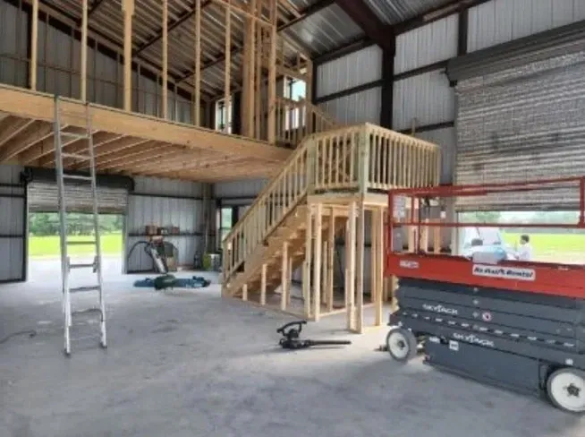 A red scissor lift is in a building under construction