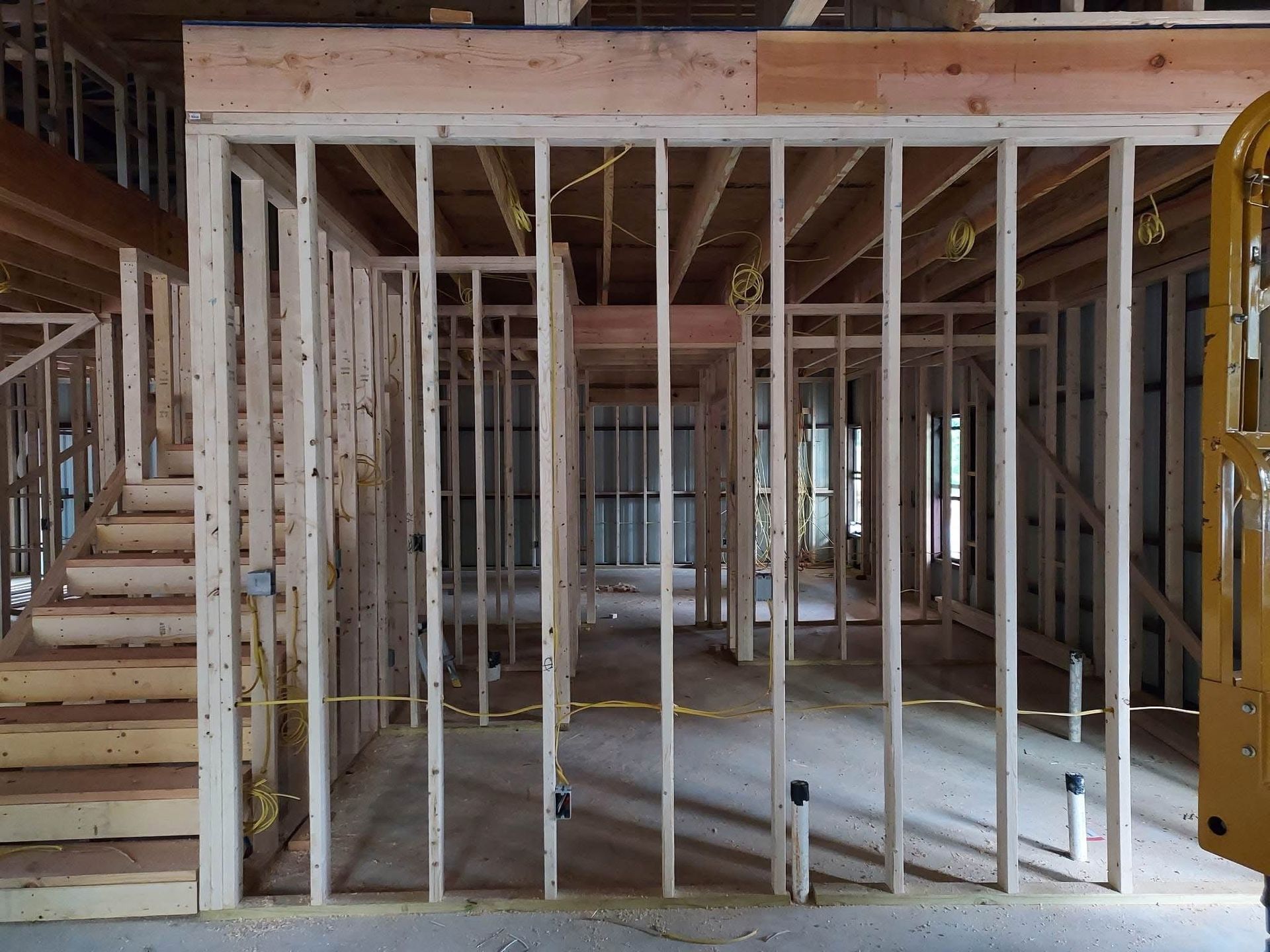 Interior view of wooden framing for a new building. Studs, beams, and joists are visible.
