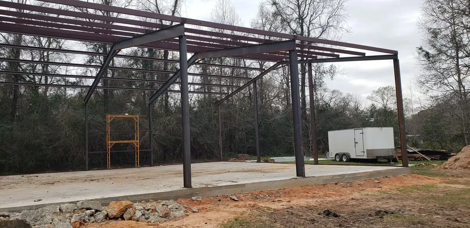 A large metal structure is being built in the middle of a field.