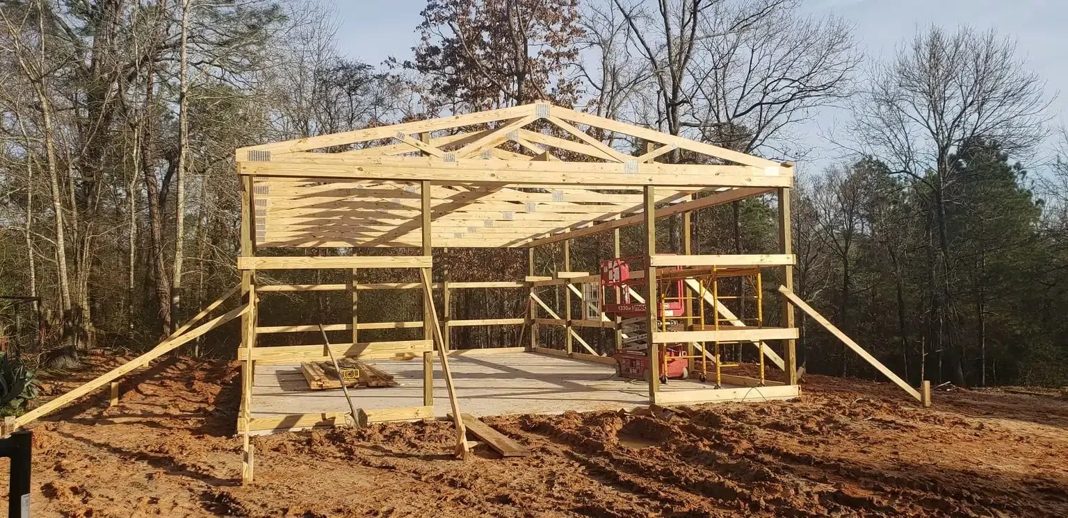 A wooden structure is being built in the middle of a dirt field.