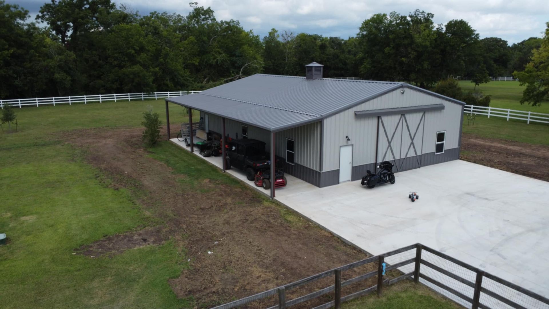 Metal workshop building with a grey roof and siding, on a concrete pad.