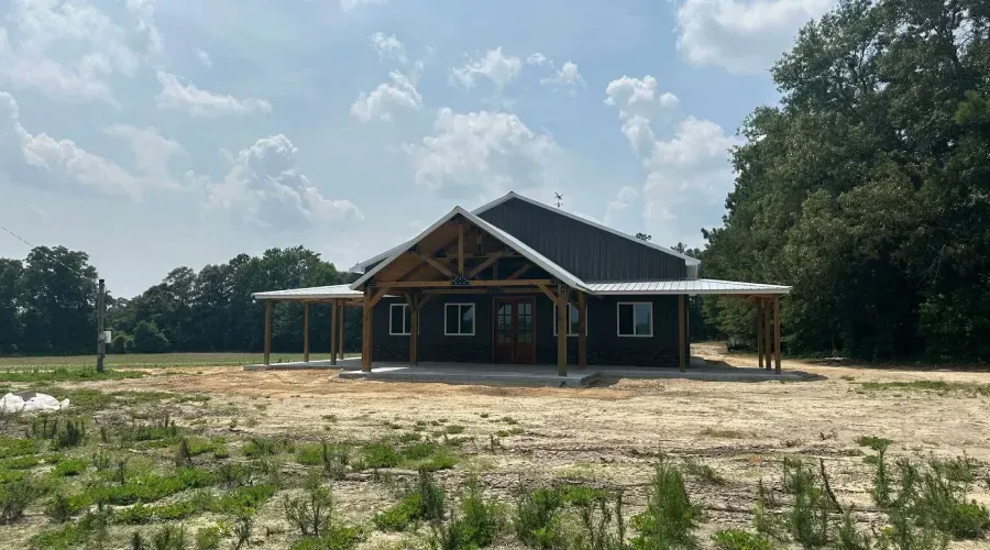 A house is being built in a field with trees in the background.