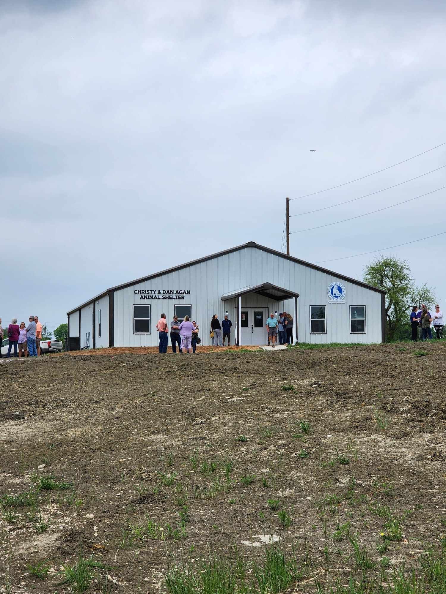 White building with people outside; overcast sky.