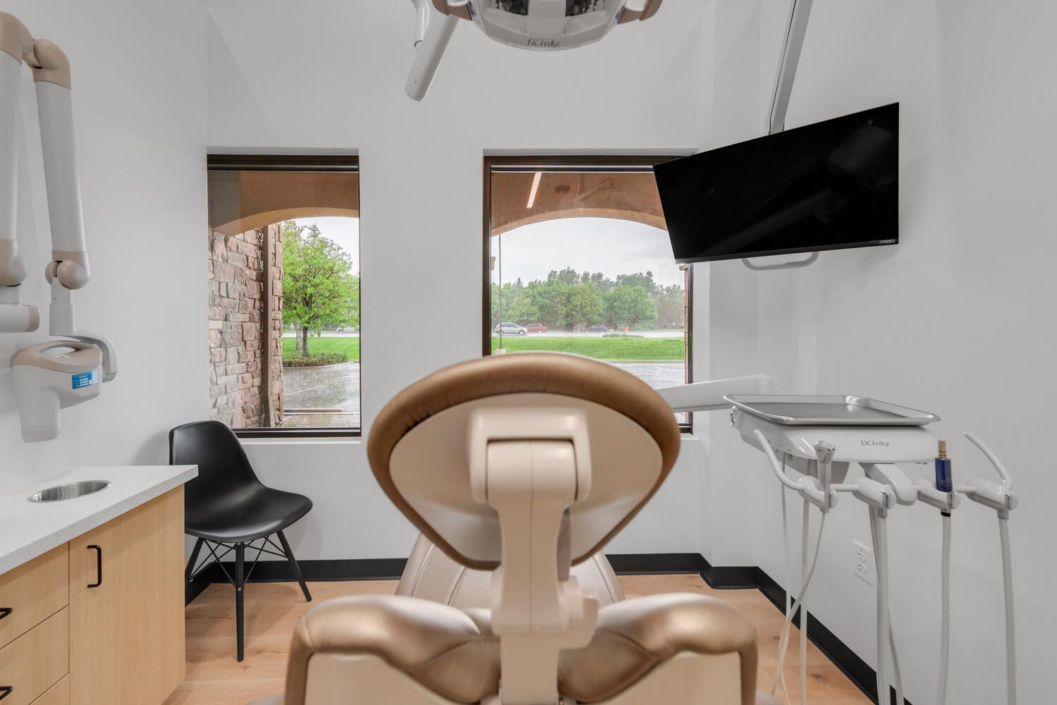 a dental office with a dental chair and a television on the wall .