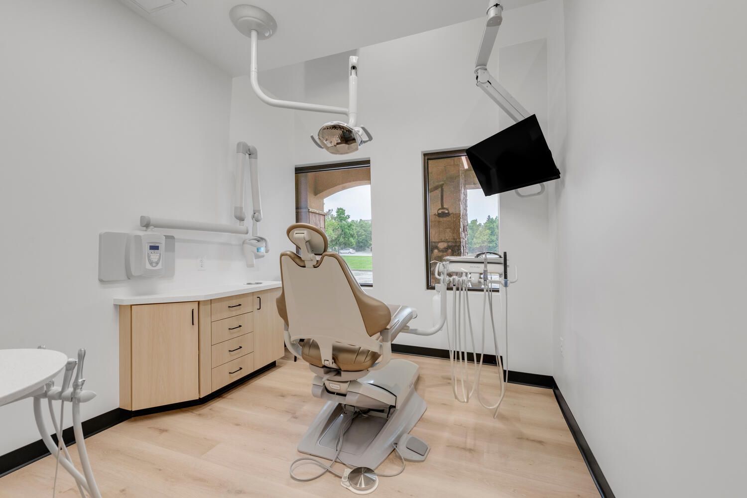 a dental office with a dental chair and a television on the wall .