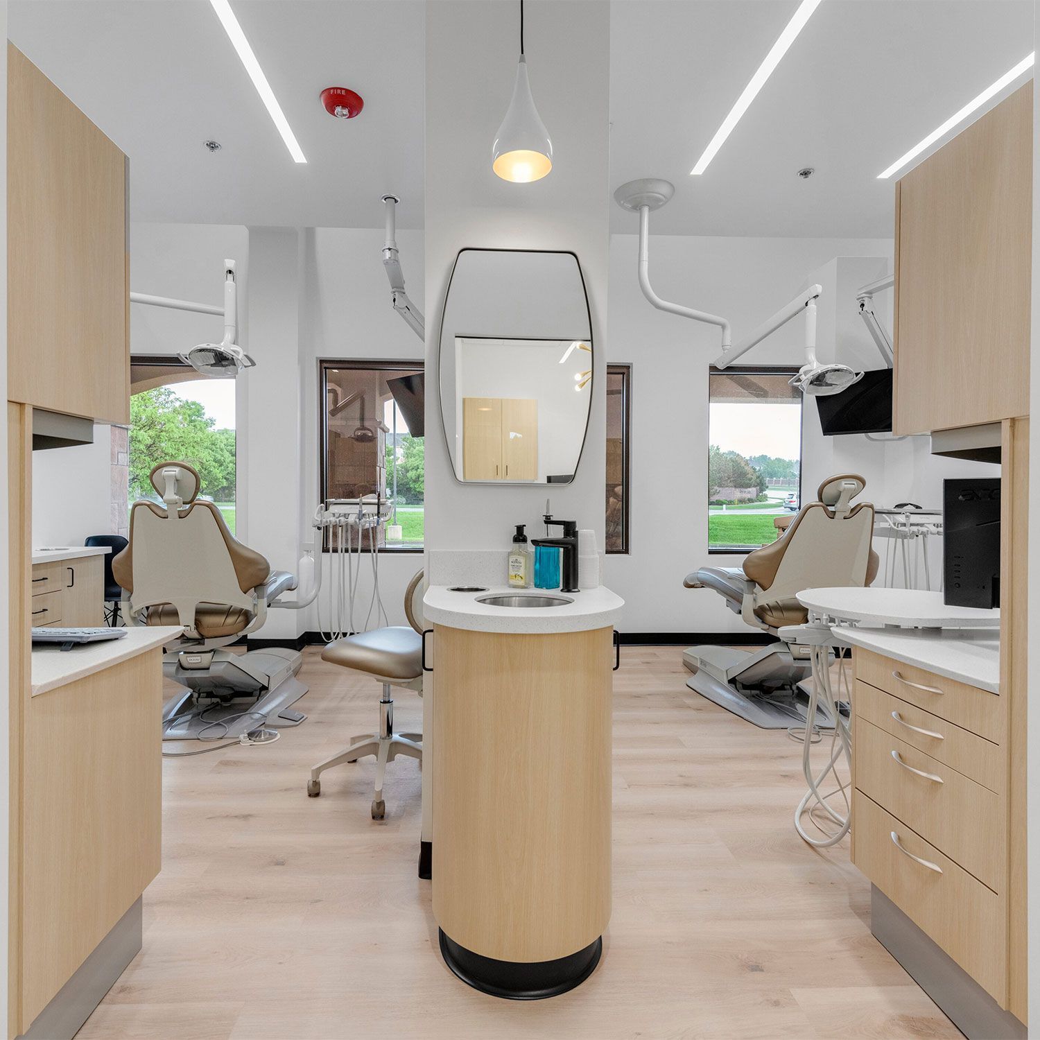 a dental office with two dental chairs and a mirror