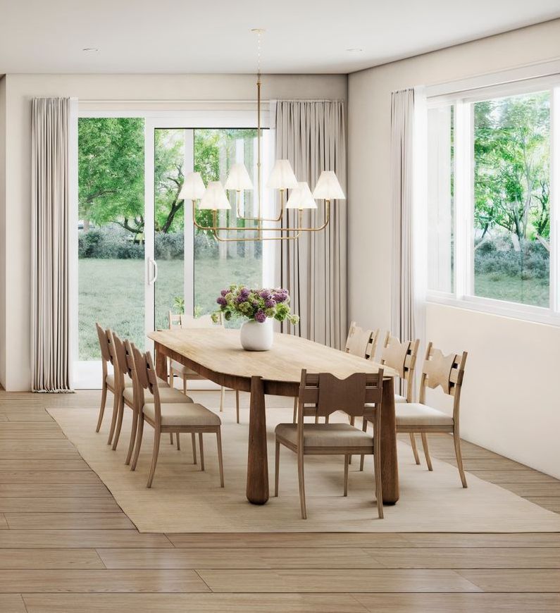 Dining room with long wooden table, chairs, and a chandelier. Large window with garden view.