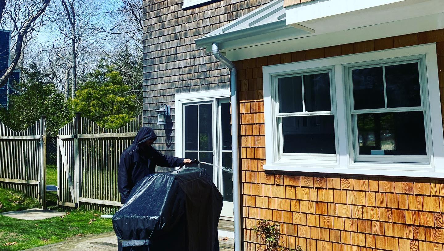 a man is standing next to a grill in front of a house .