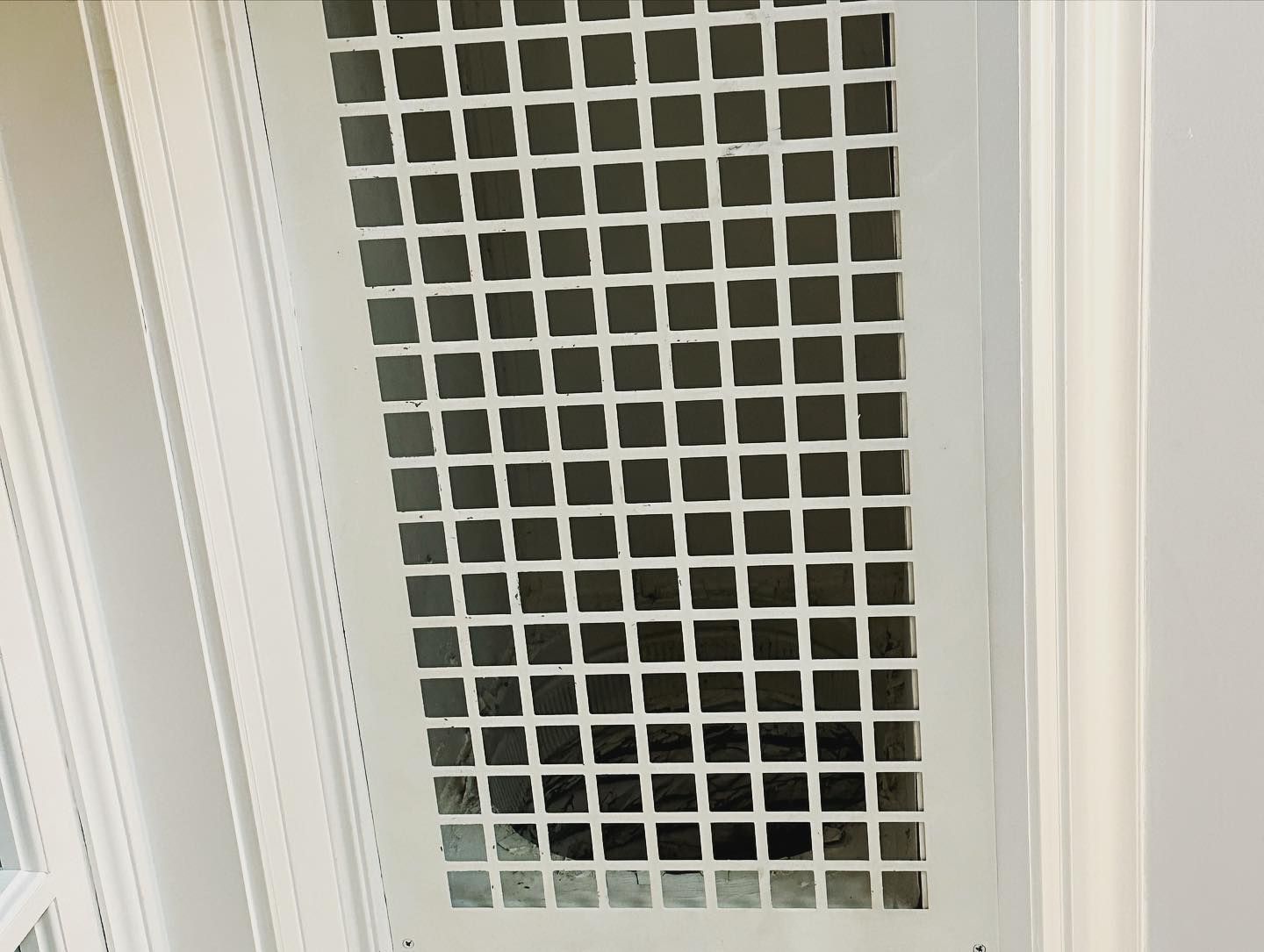 a white door with a black square pattern on it .