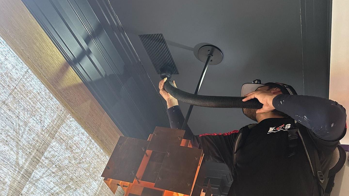 Technician removing dust from air ducts in a Long Island home