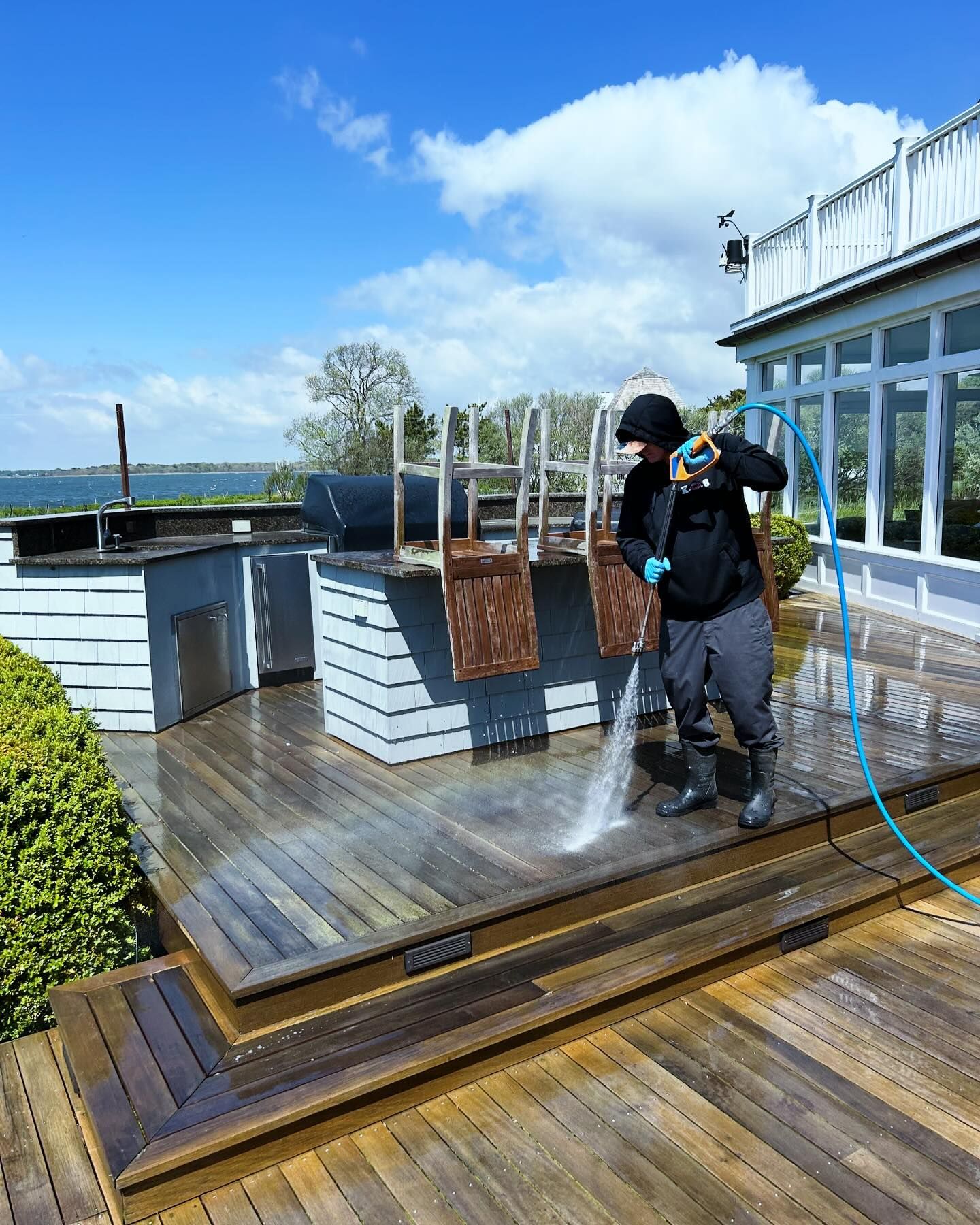 K.O.S. cleaning is delivering pressure washing services on a deck on Long Island. 