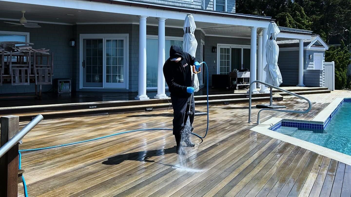 KOS Cleaning is pressure washing a pool deck at a home on Long Island 