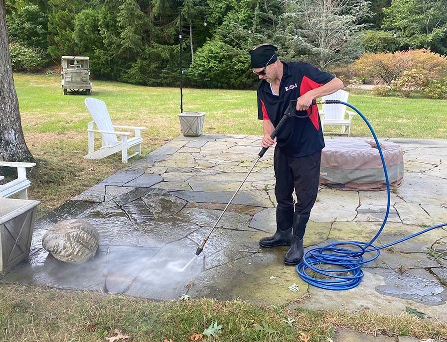 KOS Cleaning pressure washing a patio at a Long Island home 