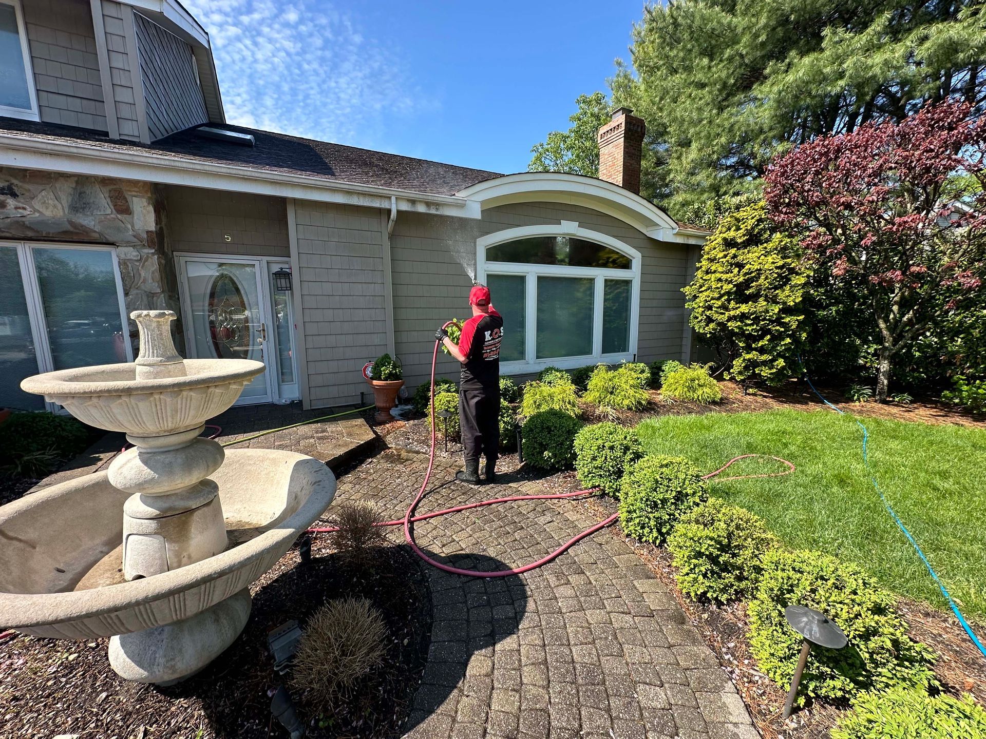 Technician soft washing a home in Suffolk County Long island.