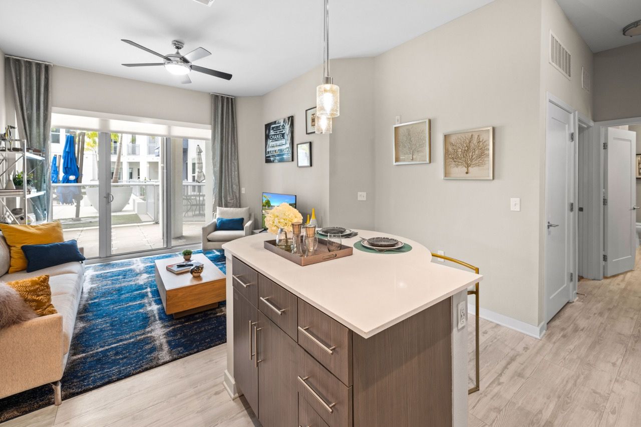 Open-concept living area with a kitchen island and sliding glass doors to a balcony.