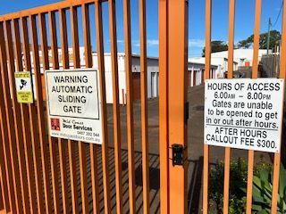 A Fence With Signs On It That Say Warning Automatic Sliding Gate  — Acacia Mini Storage in Port Macquarie, NSW