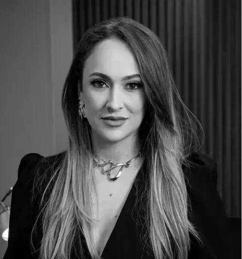 Um homem de terno e camisa branca está sorrindo em uma foto em preto e branco.