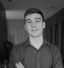 Uma foto em preto e branco de um jovem com os braços cruzados.