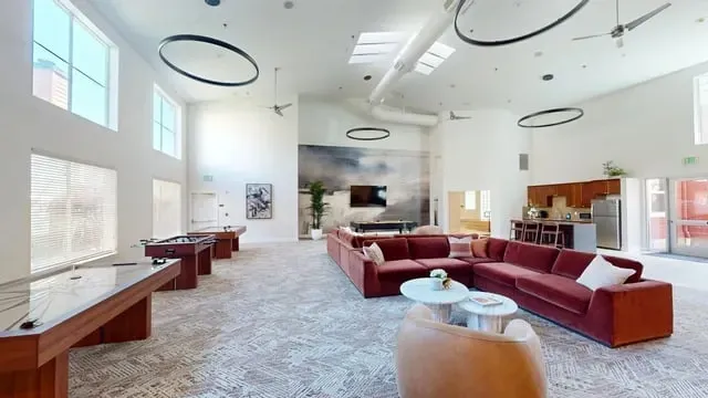 Spacious resident lounge with pool tables, foosball, and a large sectional sofa.