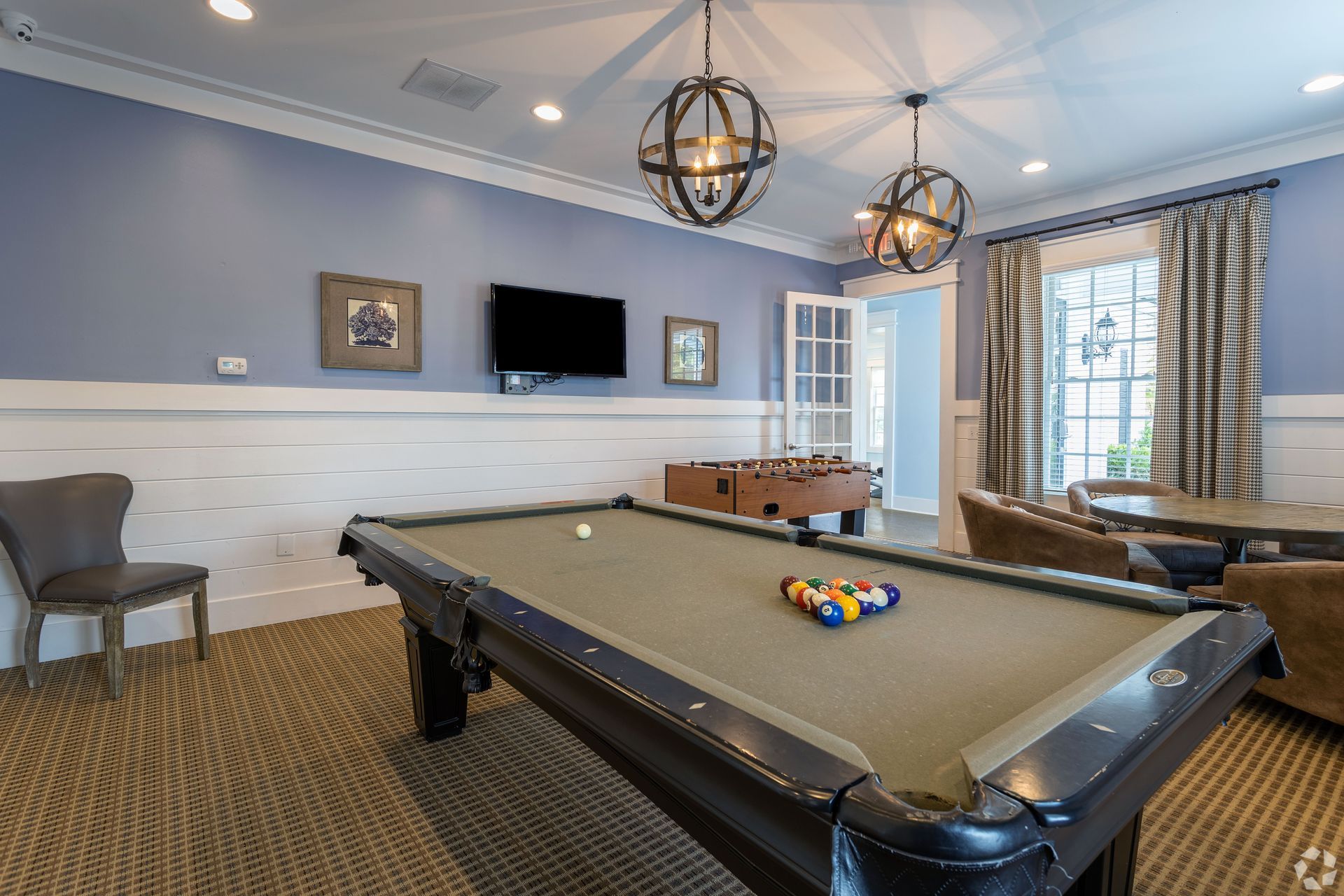 Pool table in a game room with blue walls, a foosball table, and globe pendant lights at Preserve at Godley Station in Pooler, GA.
