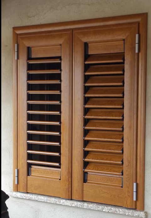 Persiane in legno marrone, chiuse, su una finestra, con stecche orizzontali.