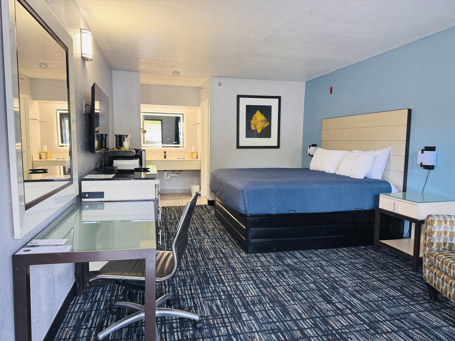 A hotel room with a king size bed and a desk
