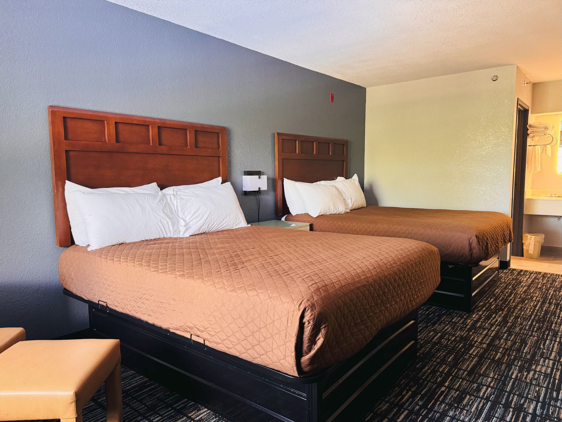 A hotel room with two beds and a chair