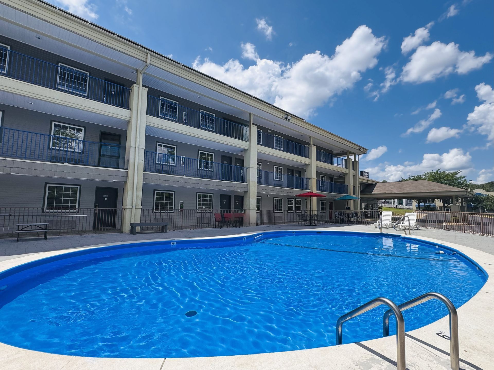 There is a large swimming pool in front of a hotel.