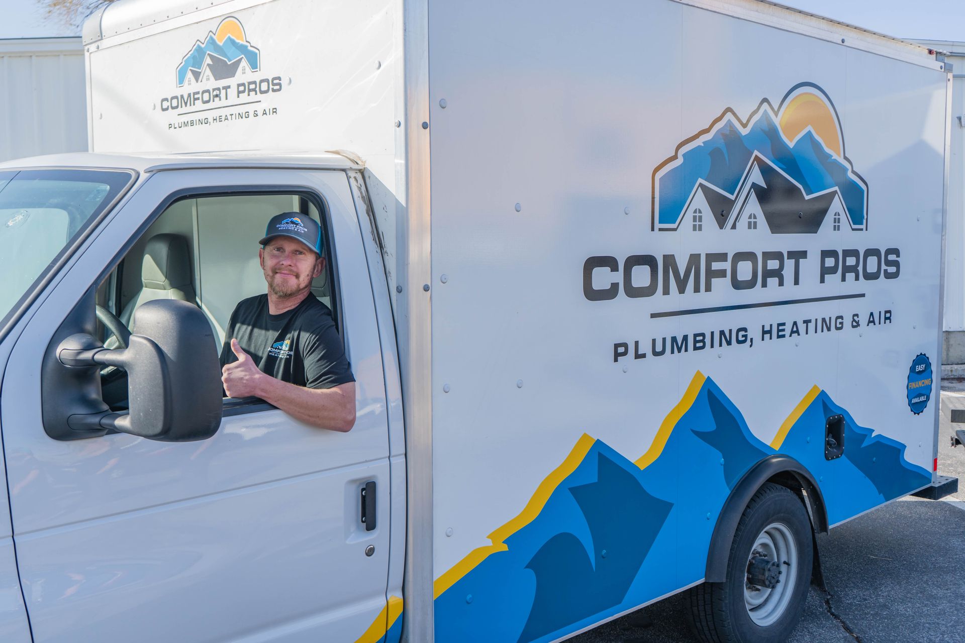 A woman and a child are sitting on a window sill looking out the window.