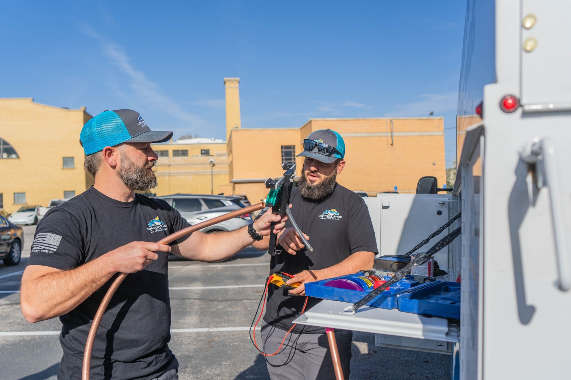 Two air conditioners are sitting on the side of a house.